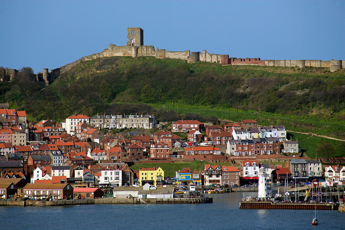 View over town and harbour to Scarborough Castle, Scarborough, Yorkshire, UK, England