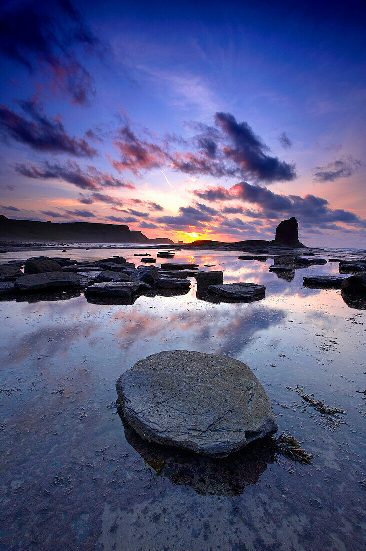Saltwick Bay with Black Nab rock at low tide at dusk in summer, Whitby, Yorkshire, UK, England