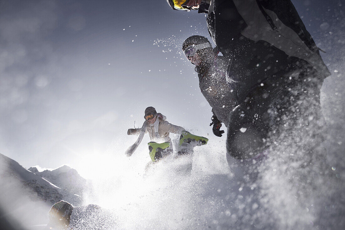 vier junge Leute springen durch den Schnee, Kühtai, Tirol, Österreich