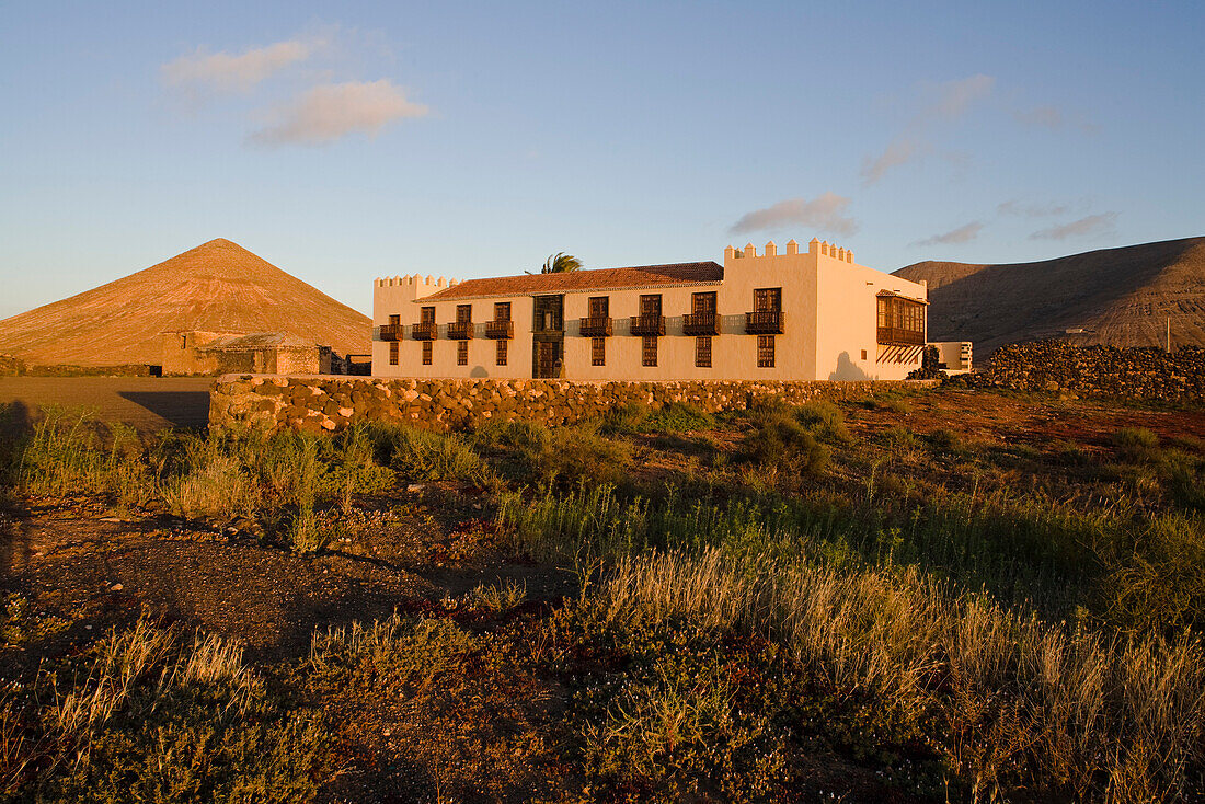 Der erloschene Vulkan Montana Oliva hinter dem historischen Gebäude Casa de Los Coroneles, La Oliva, Fuerteventura, Kanarische Inseln, Spanien, Europa