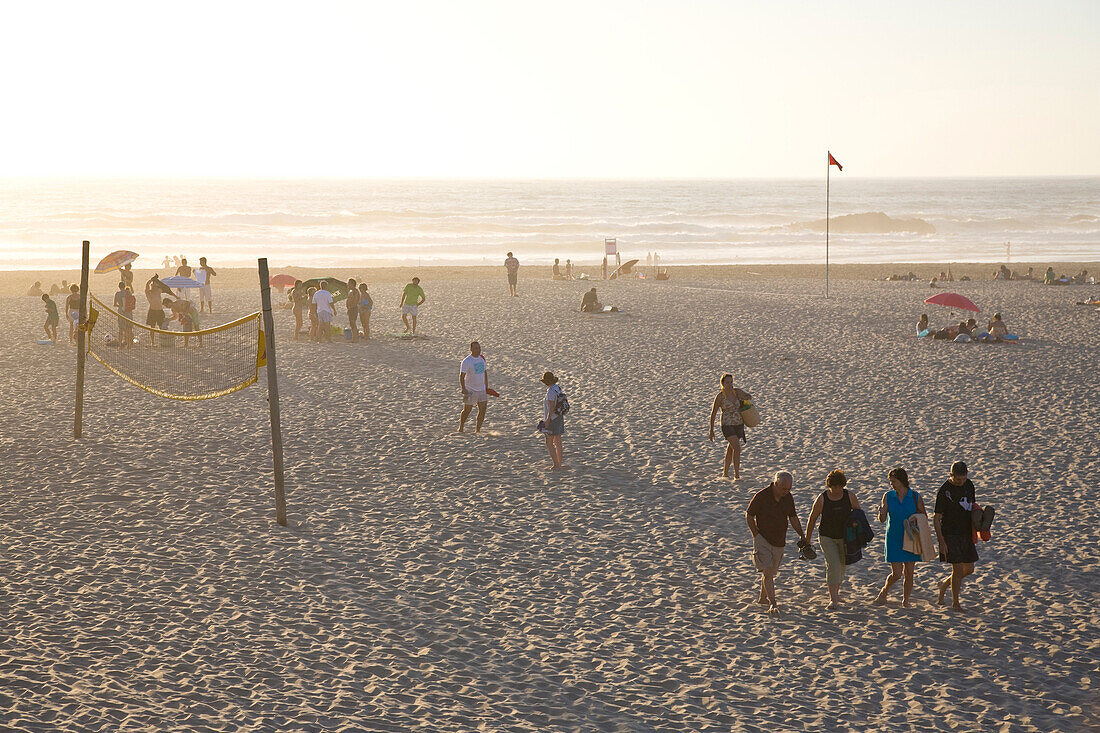Leute am Strand im Abendlicht, Volleyball Netz, Atlantik, beliebter Strand von Windsurfern, Praia de Odeceixe, Algarve, Portugal