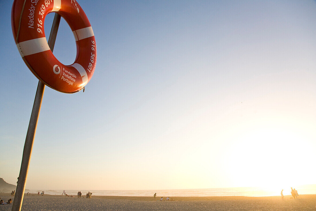 Pole with lifesafer, lifering, beach at sunset, Atlantic ocean, popular beach among wind surfers, Praia de Odeiceixe, Algarve, Portugal