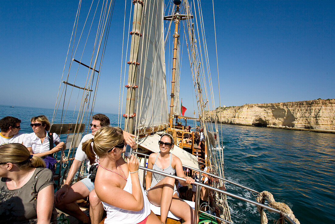 Touristen, Maedchen fotografieren sich auf dem Deck, Segelschiff Santa Bernada, fuer touristische Zwecke umgebautes altes Segelschiff, Fahrten entlang der Felsenkueste, Portimao, Algarve, Portugal