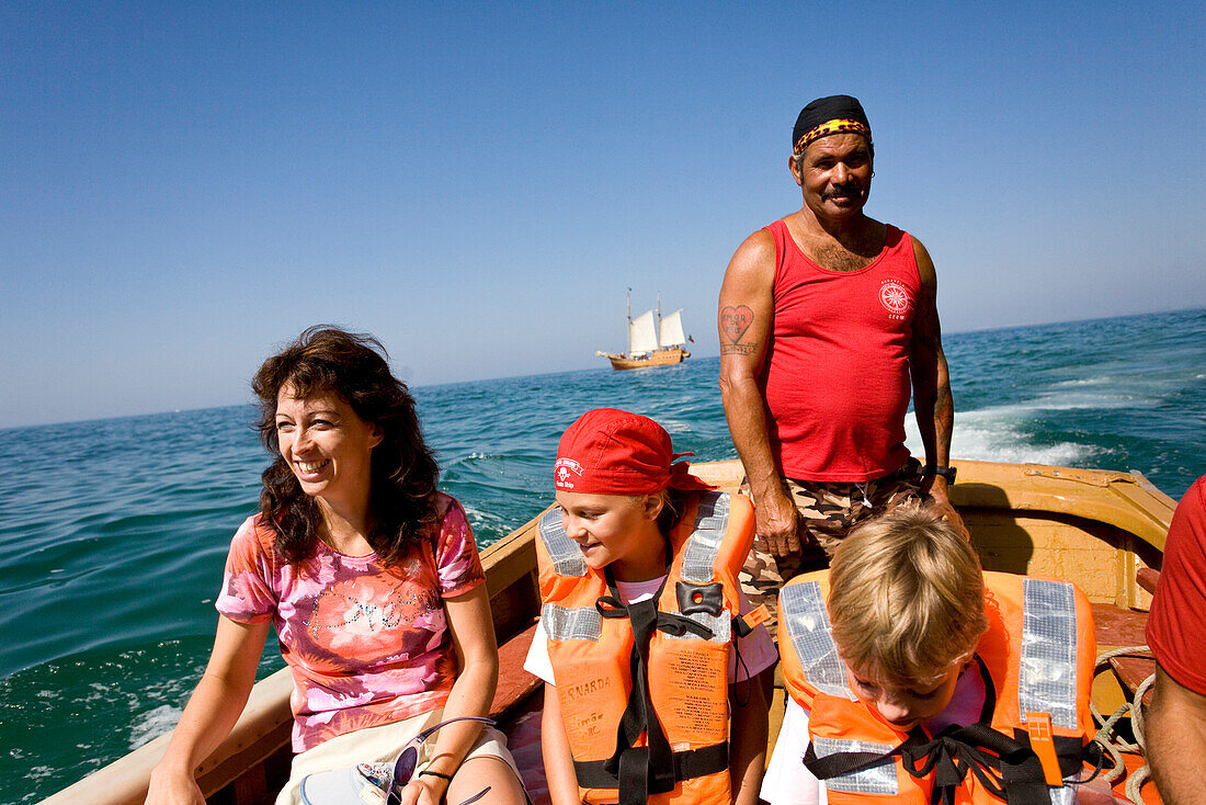 Touristen im Schlauchboot, Mutter mit Kindern, Segelschiff Santa Bernada im Hintergrund, fuer touristische Zwecke umgebautes altes Segelschiff, Fahrten entlang der Felsenkueste, Portimao, Algarve, Portugal