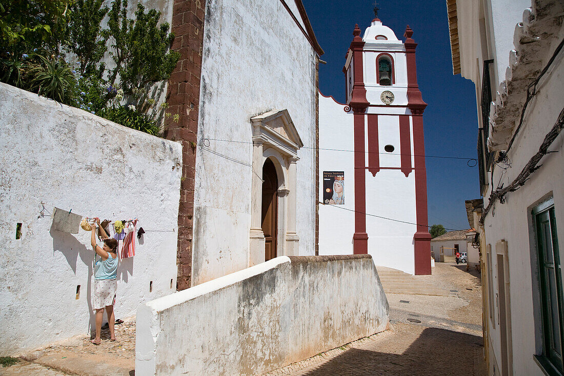 Misericordia Kirche in Silves, Frau haengt Waesche auf, Silves, Algarve, Portugal