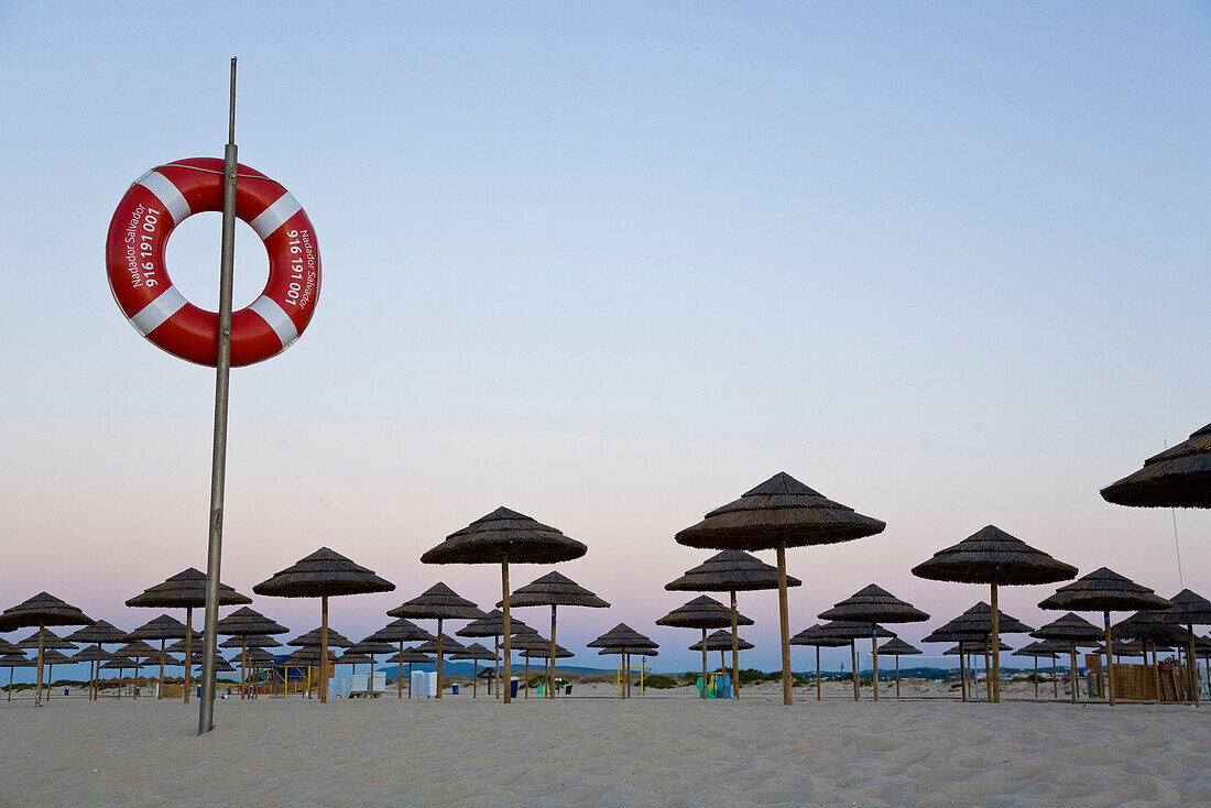 Rettungsring und Strandschirme, Strand auf der Insel Ilha de Tavira bei Morgendaemmerung, Tavira, Algarve, Portugal