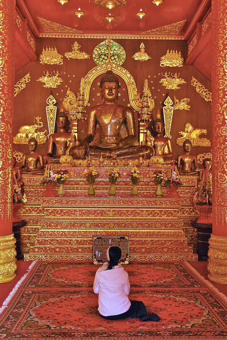 Frau betet vor Buddha, Wat Phra Kaeo, Chiang Rai, Goldenes Dreieck, Thailand, Asien