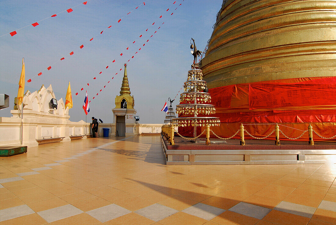 Plattform with golden chedi and two persons on the Golden Mount in Bangkok, Thailand, Asia