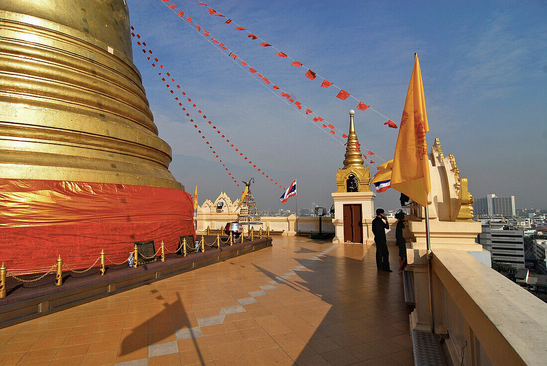 Plattform with golden chedi and two persons on the Golden Mount in Bangkok, Thailand, Asia