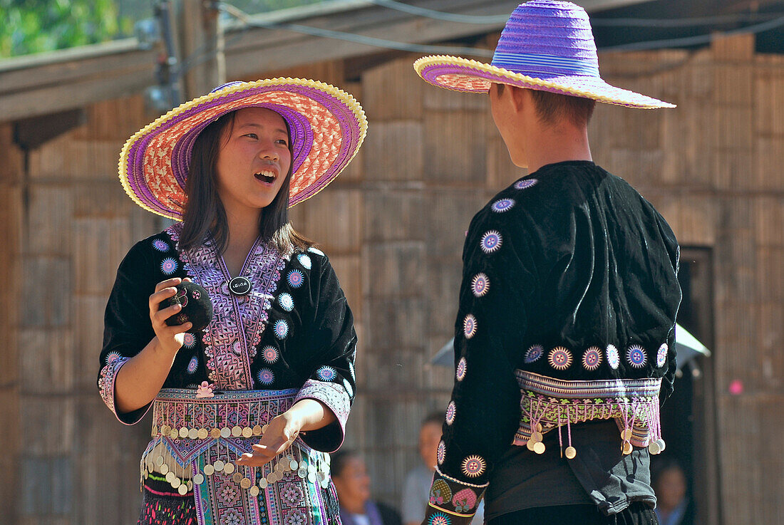 Hmong Frau und Mann mit Ball in traditioneller Tracht zur Neujahrsfeier, Mae Rim Valley, Hmong Dorf, Provinz Chiang Mai, Thailand, Asien