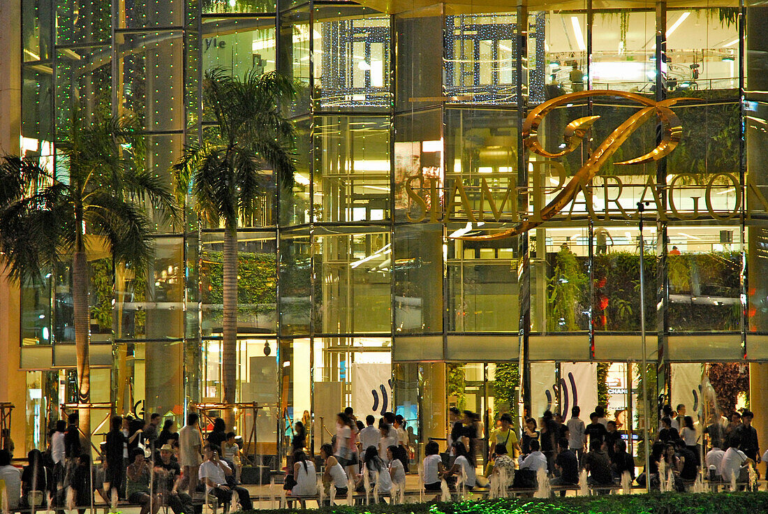 Menschen am Abend vor der Glasfassade des Paragon Einkaufzentrums am Siam Square, Thailand, Asien
