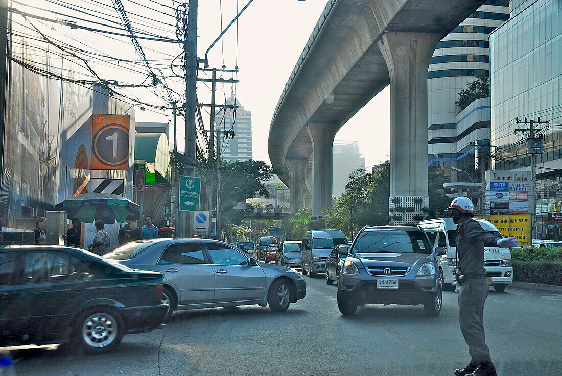 Traffic and traffic policeman under the Skytrain, Sukhumvit, Bangkok, Thailand, Asia