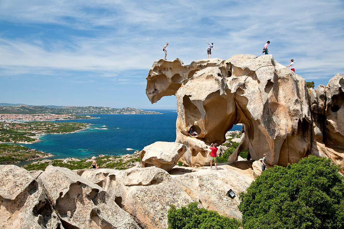 Tourists on a bear shaped rock formation, Capo d'Orso, Palau, Sardinia, Italy, Europe