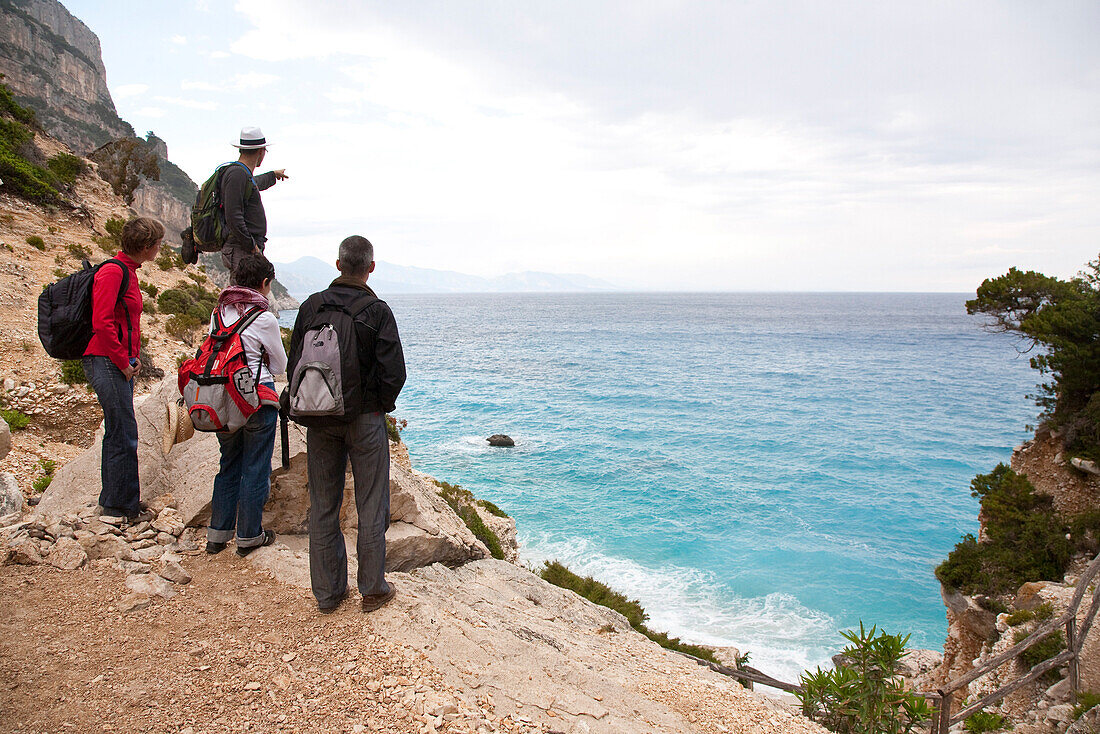 Wanderer schauen in eine Bucht im Golfo di Orosei, Sardinien, Italien, Europa