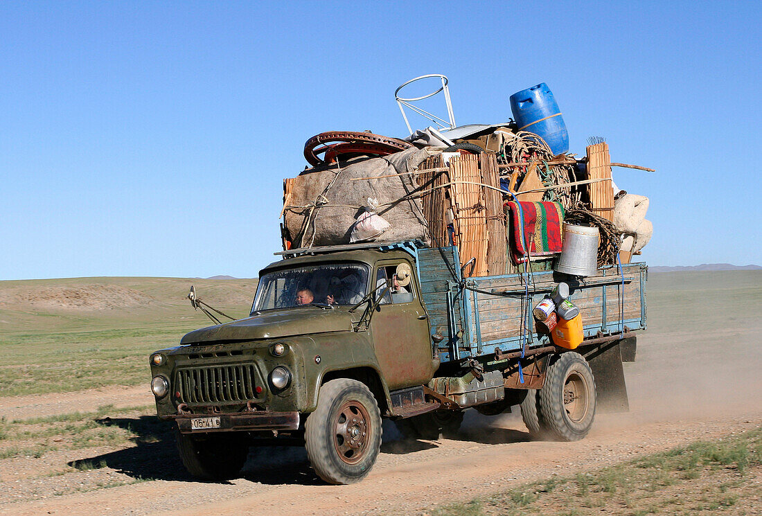 Lorry laden with family's belongings on desert road, General, Mongolia
