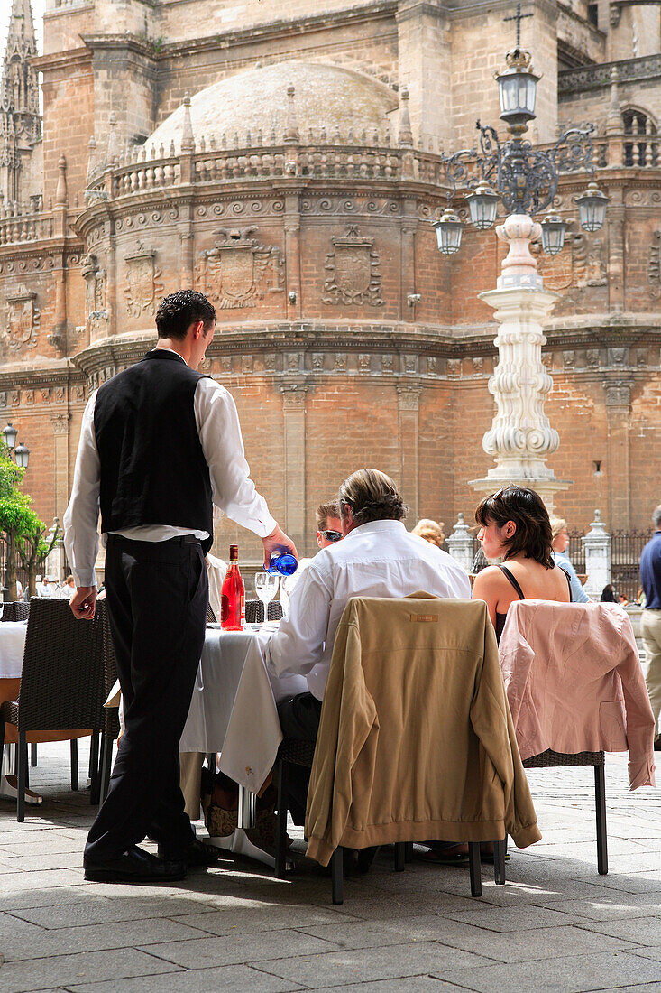 Plaza Virgen de los Reyes, waiter serving drinks in street cafe, Seville, Andalucia, Spain