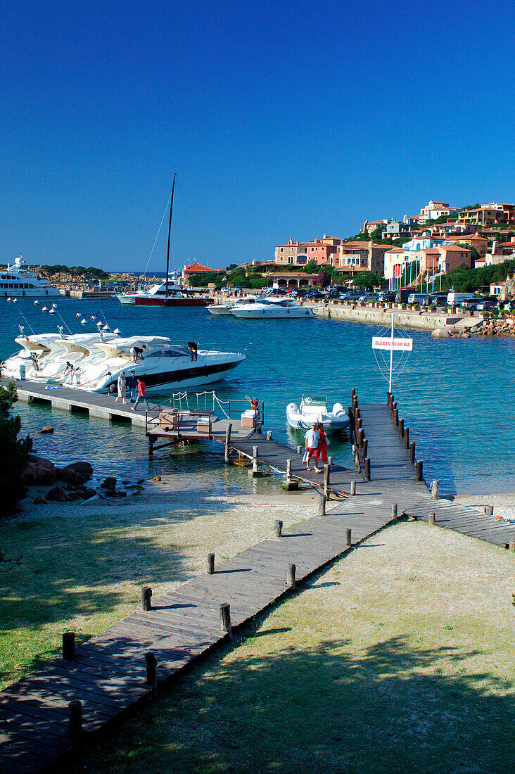 Marina and jetties with hillside town in background, Porto Cervo, Sardinia, Italy
