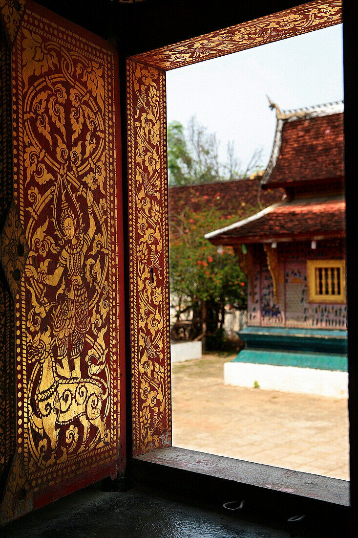 Wat Xieng Thong, view through richly painted window, Luang Prabang, Laos