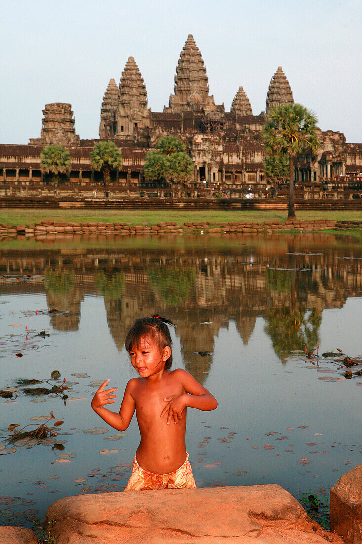 Young girl in front of Angkor Wat viewed over lake, Siem Reap, near, Cambodia