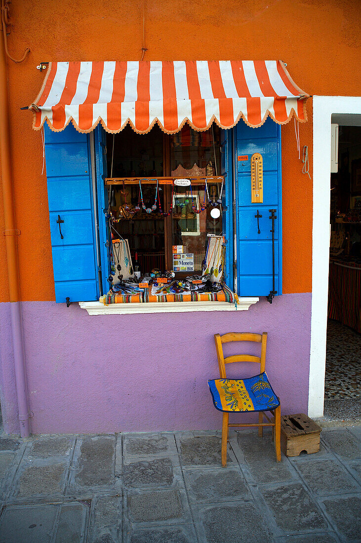 Chair and shop window on Burano Island in the Venice Lagoon, Venice, Burano, Veneto, Italy