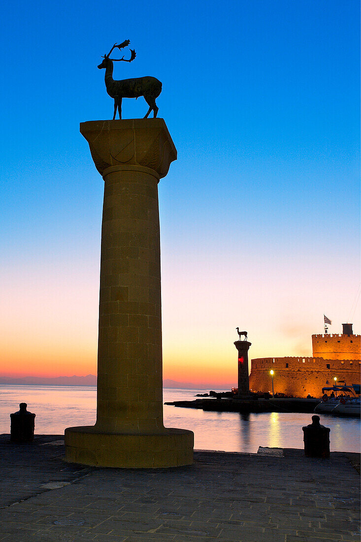 Mandraki Harbour with deer statues and St Nicholas Fort at sunset, Rhodes Town, Rhodes Island, Greek Islands