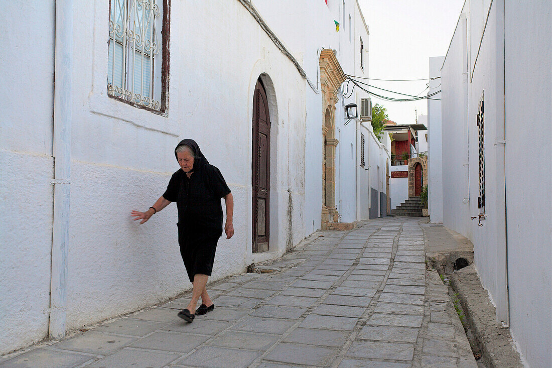 Street scene in the Old Town with old lady in black, Lindos, Rhodes Island, Greek Islands