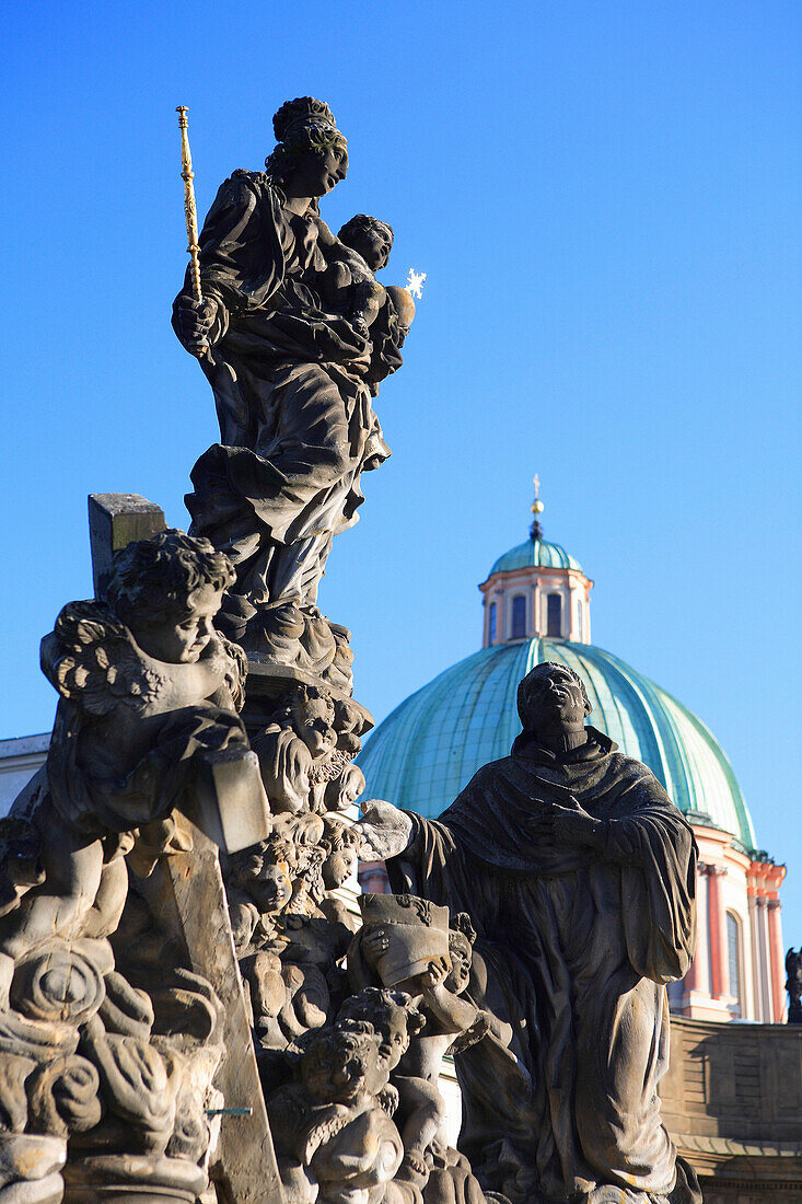 Statue on Charles Bridge and dome, Prague, Czech. Republic