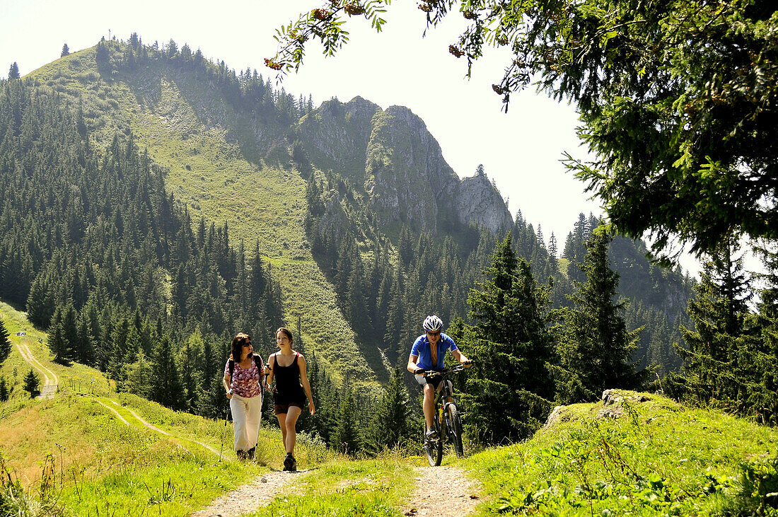 Hikers and mountain biker at Hochries, Chiemgau, Bavaria, Germany