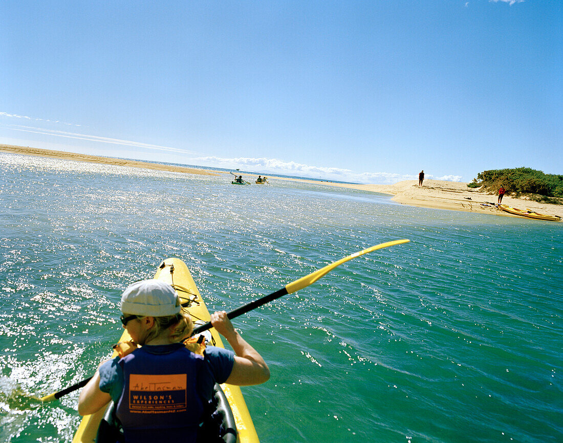 Seakayaking, junge Frau paddelt im Falls River Inlet im Sonnenlicht, Abel Tasman Nationalpark, Nordküste, Südinsel, Neuseeland