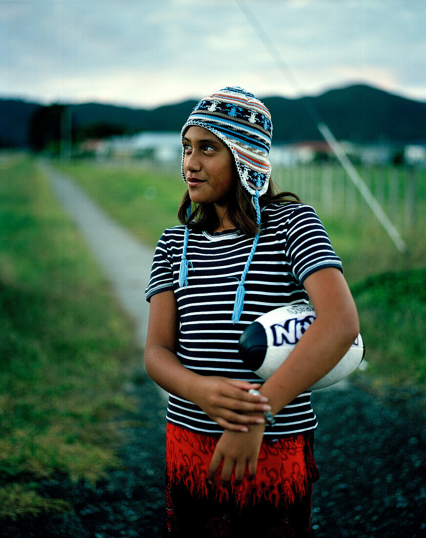 Maori girl with football at the village Hicks Bay, Eastcape, North Island, New Zealand