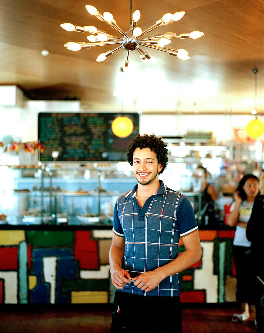Smiling waiter at Maranui Café, The Maranui Surf & Lifesaving Café, Lyall Bay Beach, Wellington, North Island, New Zealand