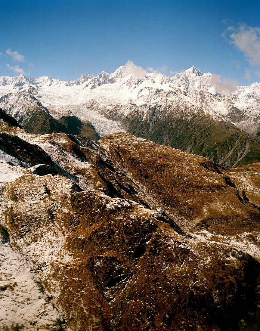 Aerial view of snow covered mountain peaks in the sunlight, Westland National Park, South Island, New Zealand