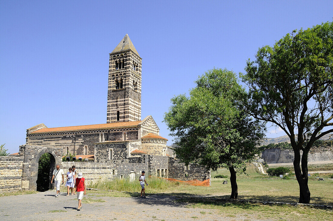 Touristen vor der Kirche Santa Trinita unter blauem Himmel, Nord Sardinien, Italien, Europa