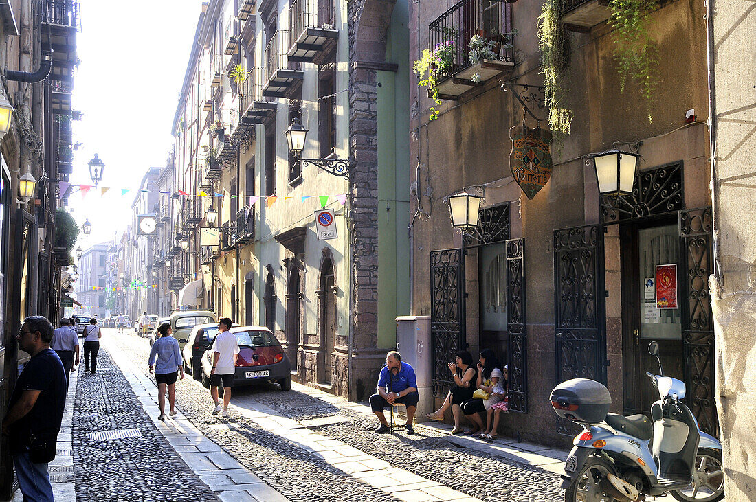 People at a sunlit street, Bosa, Sardinia, Italy, Europe