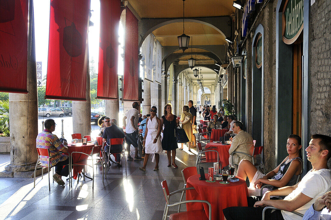 Menschen sitzen in Arkaden an der Via Roma, Cagliari, Sardinien, Italien, Europa