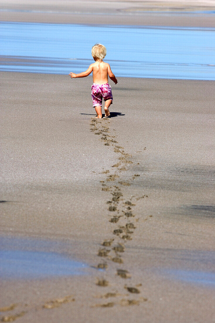 Kleines Mädchen hinterlässt Fußspuren im nassen Sand, Punta Conejo, Baja California Sur, Mexiko, Amerika