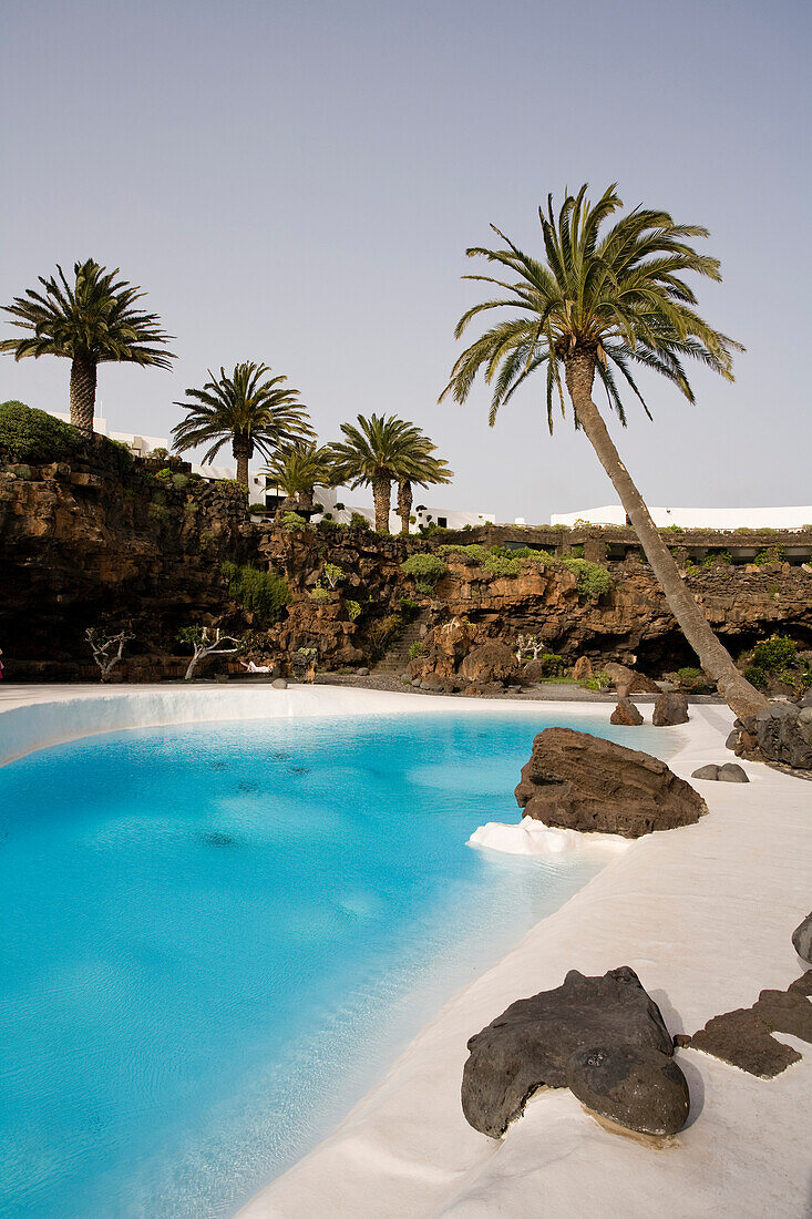 Swimming pool with palm trees near a volcanic cave, Jameos del Agua, hollow lava tunnel, architect Cesar Manrique, UNESCO Biosphere Reserve, Lanzarote, Canary Islands, Spain, Europe