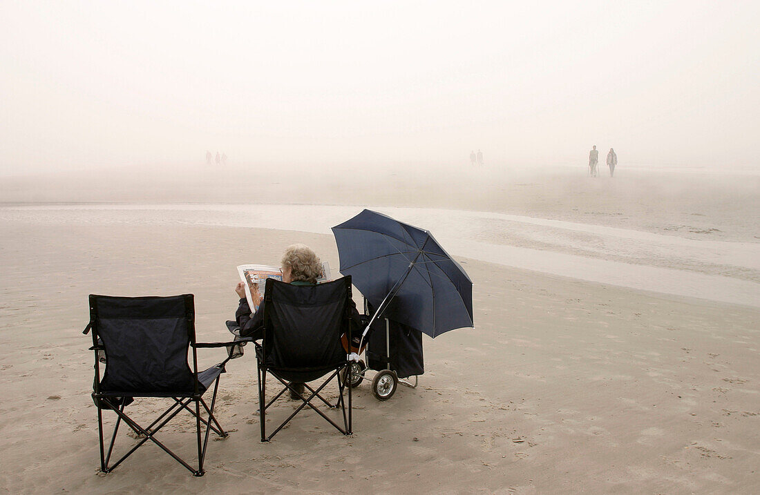Weather,  fog,  expecting the sun,  woman,  newspaper,  chairs,  trolley,  umbrella,  St.Peter-Ording,  Schleswig-Holstein,  Germany