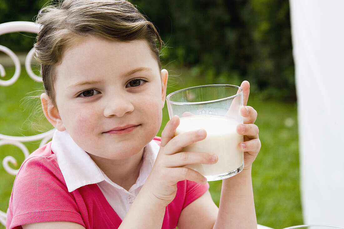 Little girl holding a glass of milk
