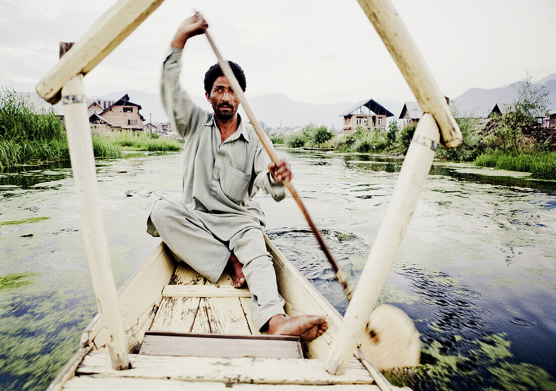 an amazing movement shot of a man paddling a boat on Dahl lake India.