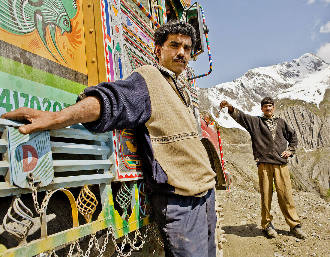 portrait of tough truck drivers by the roadside in indian mountains.
