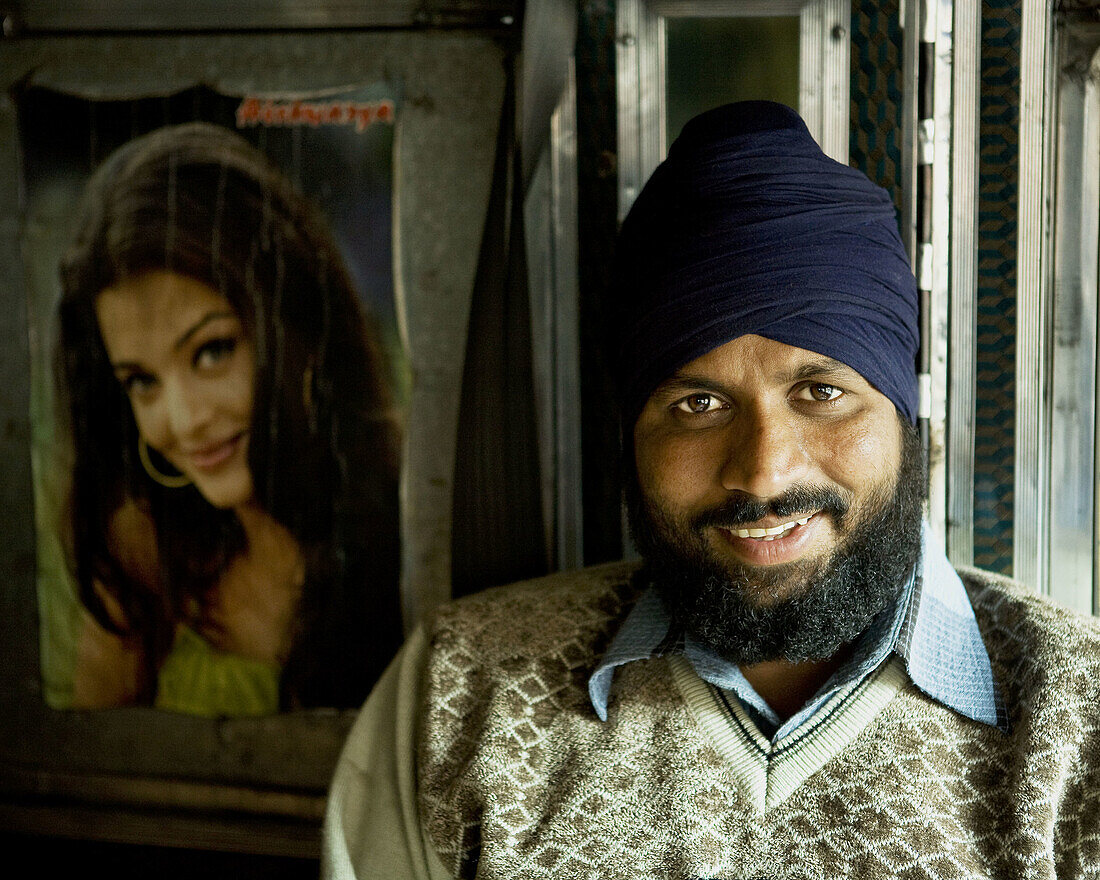 amazing closeup portrait of1 man in kashmir sitting in a tata truck.