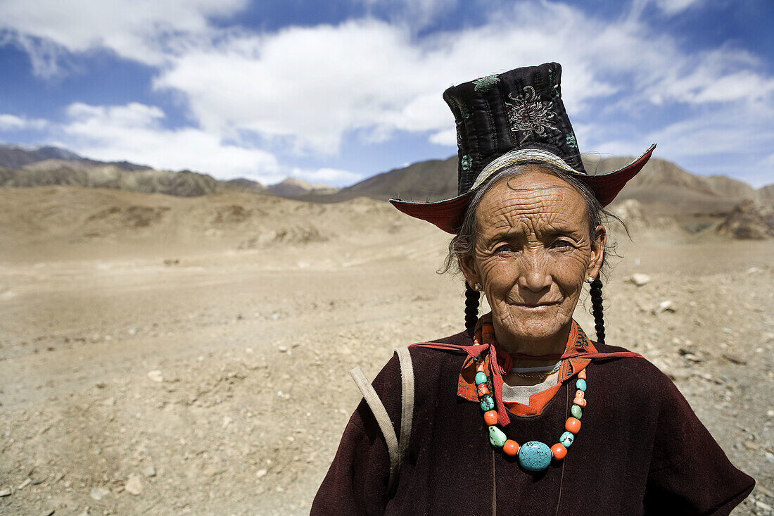 a old woman by the roadside in the mountains.