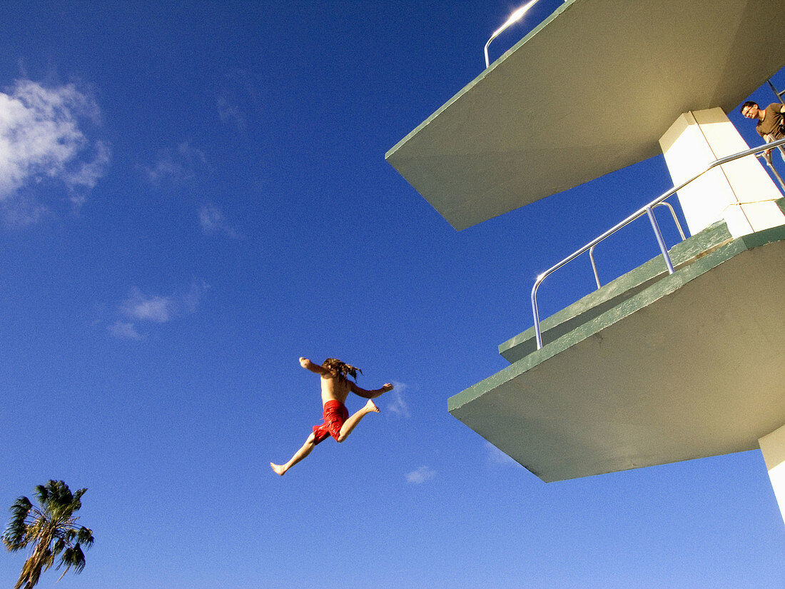 ein kleines Mädchen, Kind, springt von einem Sprungturm