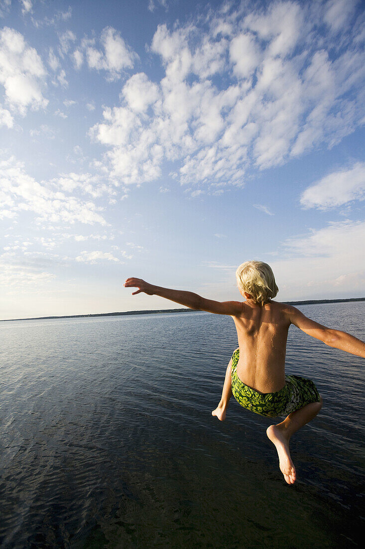 Boys leaping off a pier in Denmark