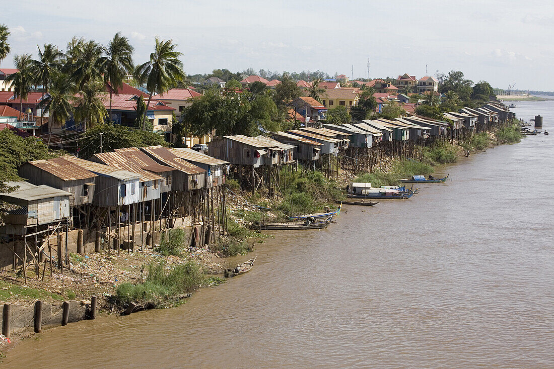 Huts built on stilts at the river Tonle Sap under clouded sky, Phnom Penh, Cambodia, Asia