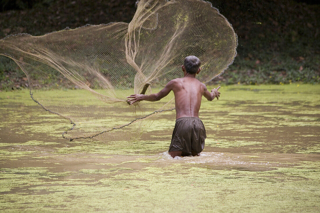 Kambodschanischer Fischer mit Fischernetz in einem Fluss, Angkor, Provinz Siem Reap, Kambodscha, Asien
