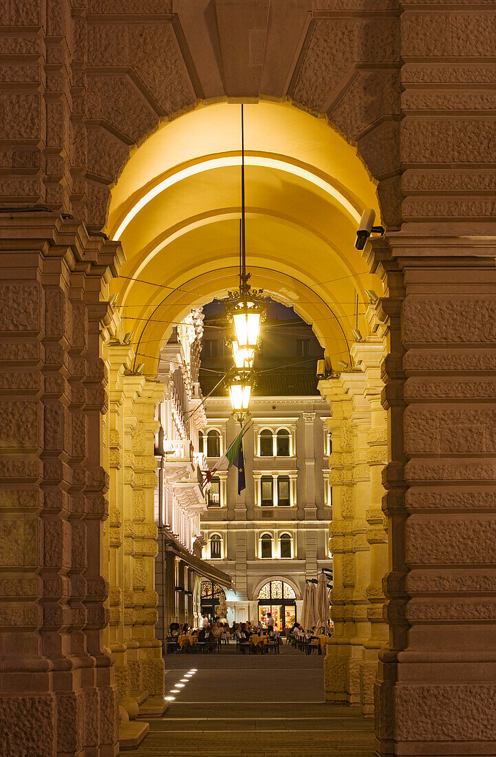 View through the arcades of the Palazzo del Governo onto the the terrace of the Cafe degli Specchi, Trieste, Friuli-Venezia Giulia, Upper Italy, Italy