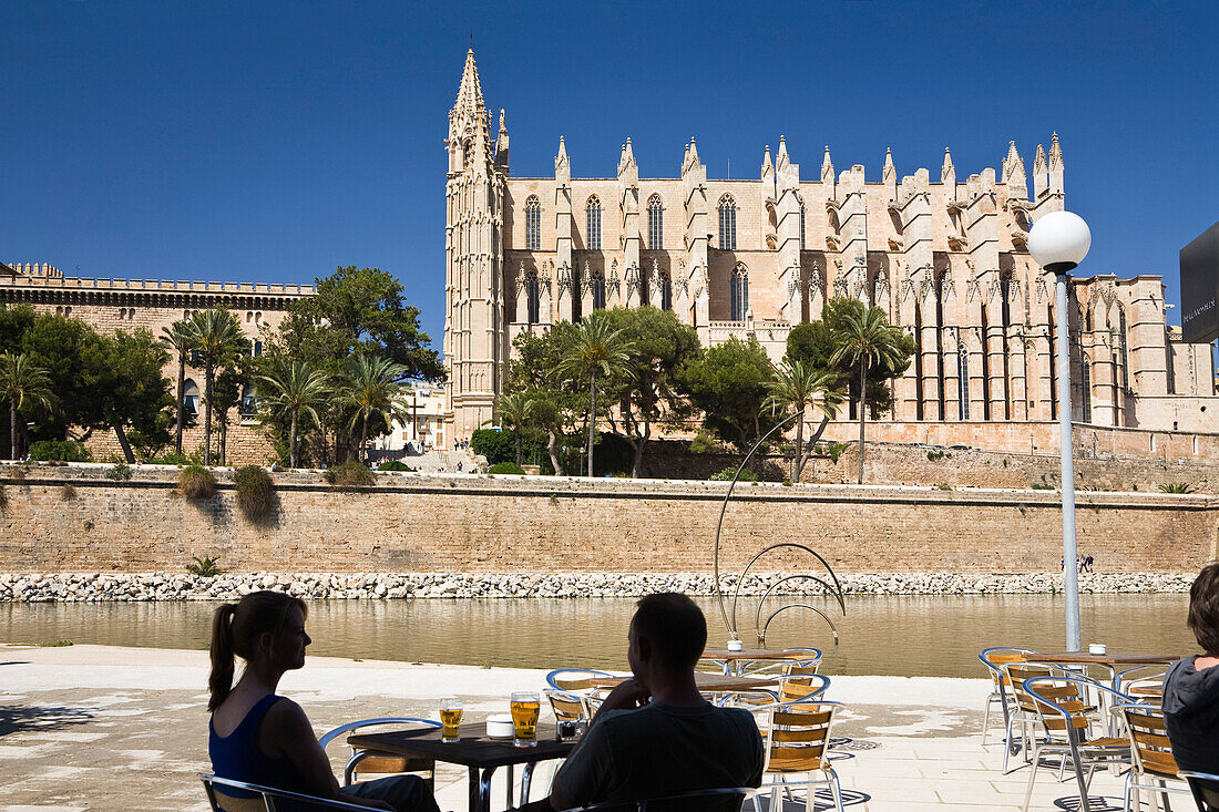 Menschen in einem Café vor der Kathedrale La Seu in Palma, Mallorca, Spanien, Europa