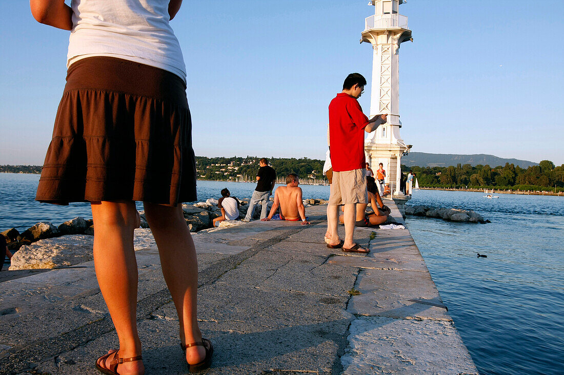 Bathing And Relaxing In Front Of The White Lighthouse Of The Bains Des Paquis In The Geneva Harbour On Lake Geneva, Geneva, Switzerland